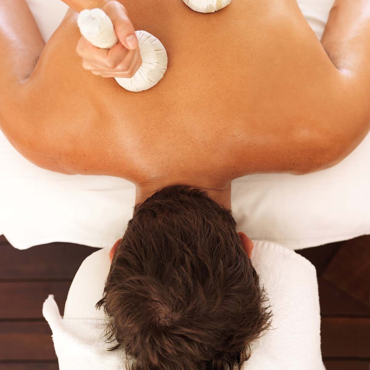 Focus on hands using massage tools to massage a man's back